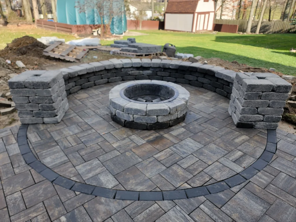 Custom outdoor patio installation with pavers and stone design
