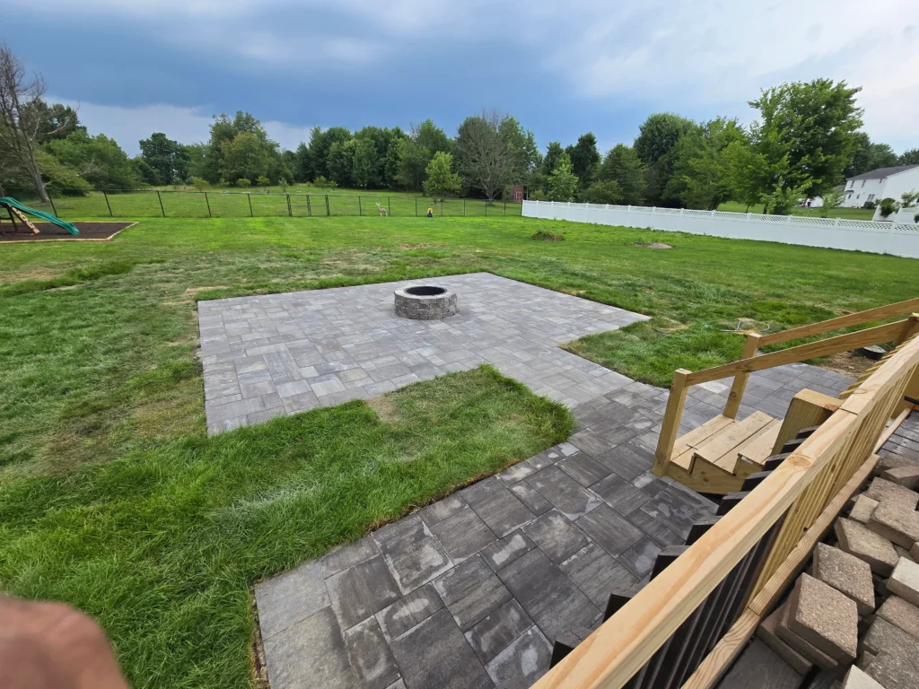 Custom outdoor patio installation with pavers and stone design