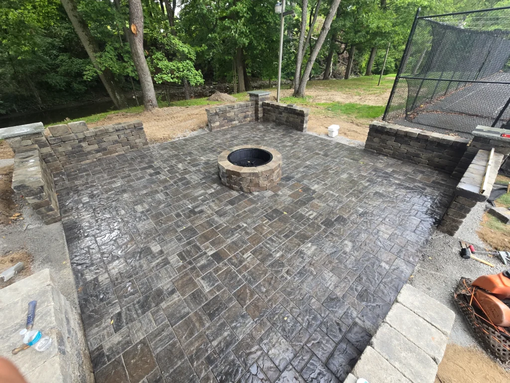 Custom outdoor patio installation with pavers and stone design