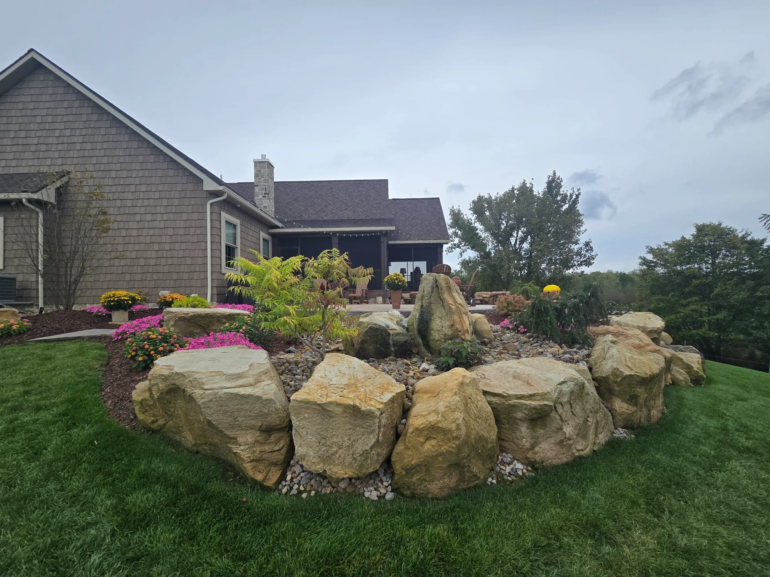 Custom hardscaping installation with stone walls, pavers, and outdoor features